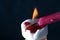 Closeup shot of a long red candle lighting a small tea candle