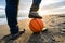 Closeup shot of male feet with a basketball on sand at a beach