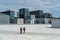 Closeup shot of a male and female walking on the urban area of the Oslo Opera building