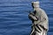 Closeup shot of a male statue carrying the cross near the sea