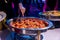 Closeup shot of a male who takes delicious food from a warm chafing dish