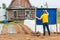 Closeup shot of a man drawing on a chalkboard on a farm with a wooden barn in the background