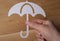 Closeup shot of a man holding a white umbrella icon on a wooden background
