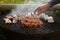 Closeup shot of a man\'s hand grilling meat on the barbecue grill