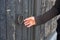 Closeup shot of a man\'s hand trying to open an old vintage door with a round iron handle