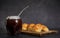 Closeup shot of medialunas croissants and yerba mate infusion placed on a wooden cutting board