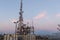 Closeup shot of a metal communication tower on a hill under a cloudy sky