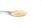 Closeup shot of a metallic spoon full of sugar under the lights isolated on a white background