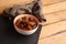 Closeup shot of Moroccan dates in white and orange bowl on a cloth on wooden background