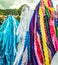 Closeup shot of multicolored lines of fabric hanging under a clouded sky