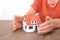 Closeup shot of old man`s hands pampering small house model on table