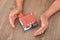 Closeup shot of old man`s hands pampering small house model on table