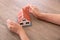 Closeup shot of old man`s hands pampering small house model on table