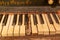 A closeup shot of an old piano keyboard with dusty damaged keys