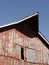 Closeup shot of the old weathered red barn in Missouri with the blue sky in the background