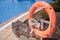 Closeup shot of an orange lifebuoy ring attached with white ropes