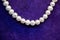 Closeup shot of pearls on a fluffy purple surface