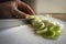 Closeup shot of a person cutting green scallions