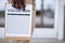 Closeup shot of a person holding a volunteer sign up sheet with a blurred background