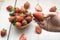 Closeup shot of a person picking a fresh strawberry from a straw bowl on a wooden surface