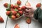 Closeup shot of a person picking a fresh strawberry from a straw bowl on a wooden surface