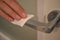 Closeup shot of a person\'s hand using antibacterial wet wipe for disinfecting door handles