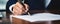 A Closeup Shot Of A Person Signing A Contract With A Pen At A Desk In Natural Daylight