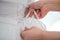 Closeup shot of a person tying a wedding dress