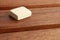 Closeup shot of a piece of butter isolated on a wooden background