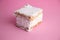 Closeup shot of a piece of cookie biscuits filled with cream isolated on a pink surface