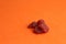 Closeup shot of pieces of dried strawberries on an orange background