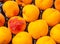 Closeup shot of a pile of juicy orange peaches at a farmer market sale