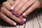 Closeup shot of pink manicure of female's short nails with purple patterns