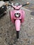 Closeup shot of pink Vespa in the street