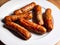 Closeup shot of a plate of grilled delicious sausages on a wooden table