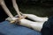 Closeup shot of a professional relaxing feet massage with a wooden stick