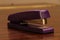 Closeup shot of a purple stapler on a wooden surface