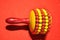 Closeup shot of a rattle percussion instrument isolated on a red background