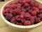 Closeup shot of red boysenberries in a wooden bowl