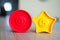 Closeup shot of a red circle and yellow star shaped plastic toy with the numbers four and five