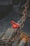 Closeup shot of a red Oval Master Lifting Ring on grunge metal surface with old metal chain