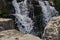 Closeup shot of a rocky splashing cascading waterfall in a forest