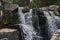 Closeup shot of a rocky splashing cascading waterfall in a forest