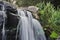 Closeup shot of a rocky splashing cascading waterfall in a forest