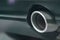 Closeup shot of a round vehicle silencer (muffler) of a black car