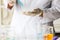 Closeup shot of scientist wears white lab coat and rubber gloves hands holding orange red reagent in glass dropper dropping into