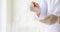 Closeup shot of scientist wears white lab coat and rubber gloves hands holding orange red reagent in glass dropper dropping into