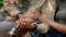 Closeup Shot Of Senior Couple Holding Hands While Relaxing Outdoors In Garden