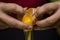 Closeup shot of separating egg whites from yolks with a black background