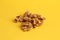 Closeup shot of a shelled walnut pile on a yellow background